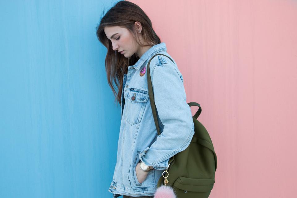 Ritagli di tessuto denim di tonalit&agrave; diverse accanto a un paio di forbici da sarto