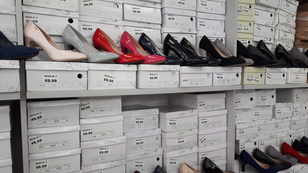 Scaffali di un negozio di calzature con paia di scarpe esposte in fila