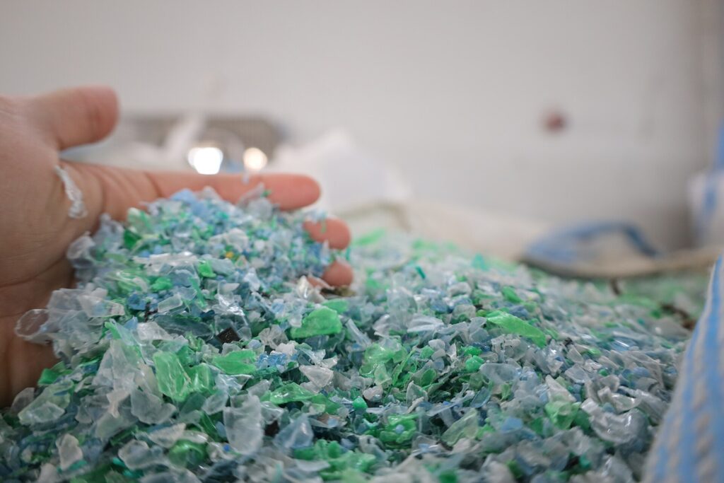 Scaglie di plastica macinata che scorrono su un nastro trasportatore in un impianto