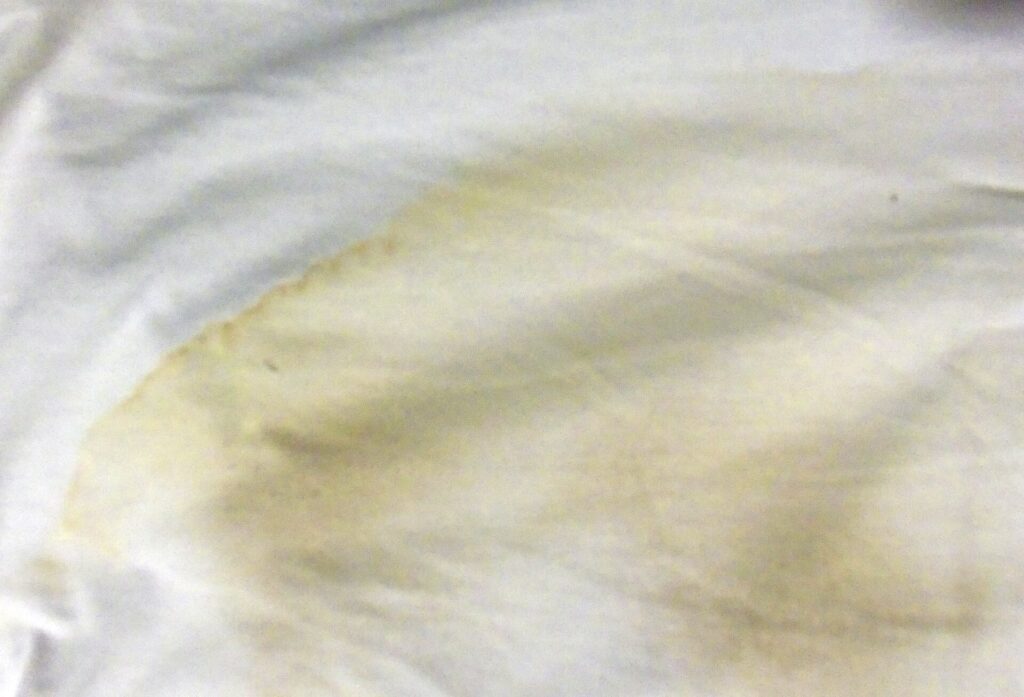 Camicie bianche in cotone appese in fila su una stanga di metallo