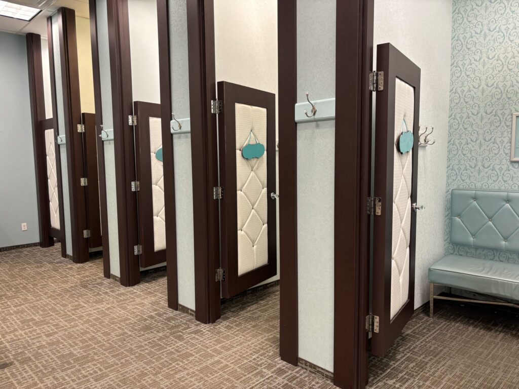 Camerino di un negozio con specchio a figura intera e una tenda scostata