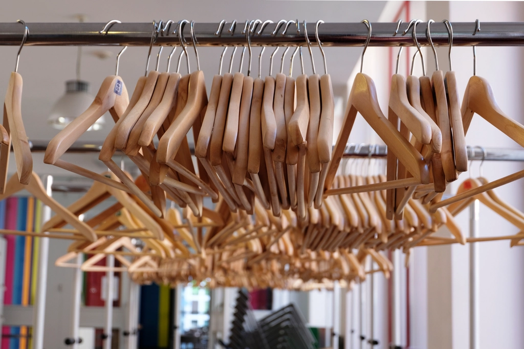 Capi appesi a una stanga in un negozio di abbigliamento con cartellini visibili